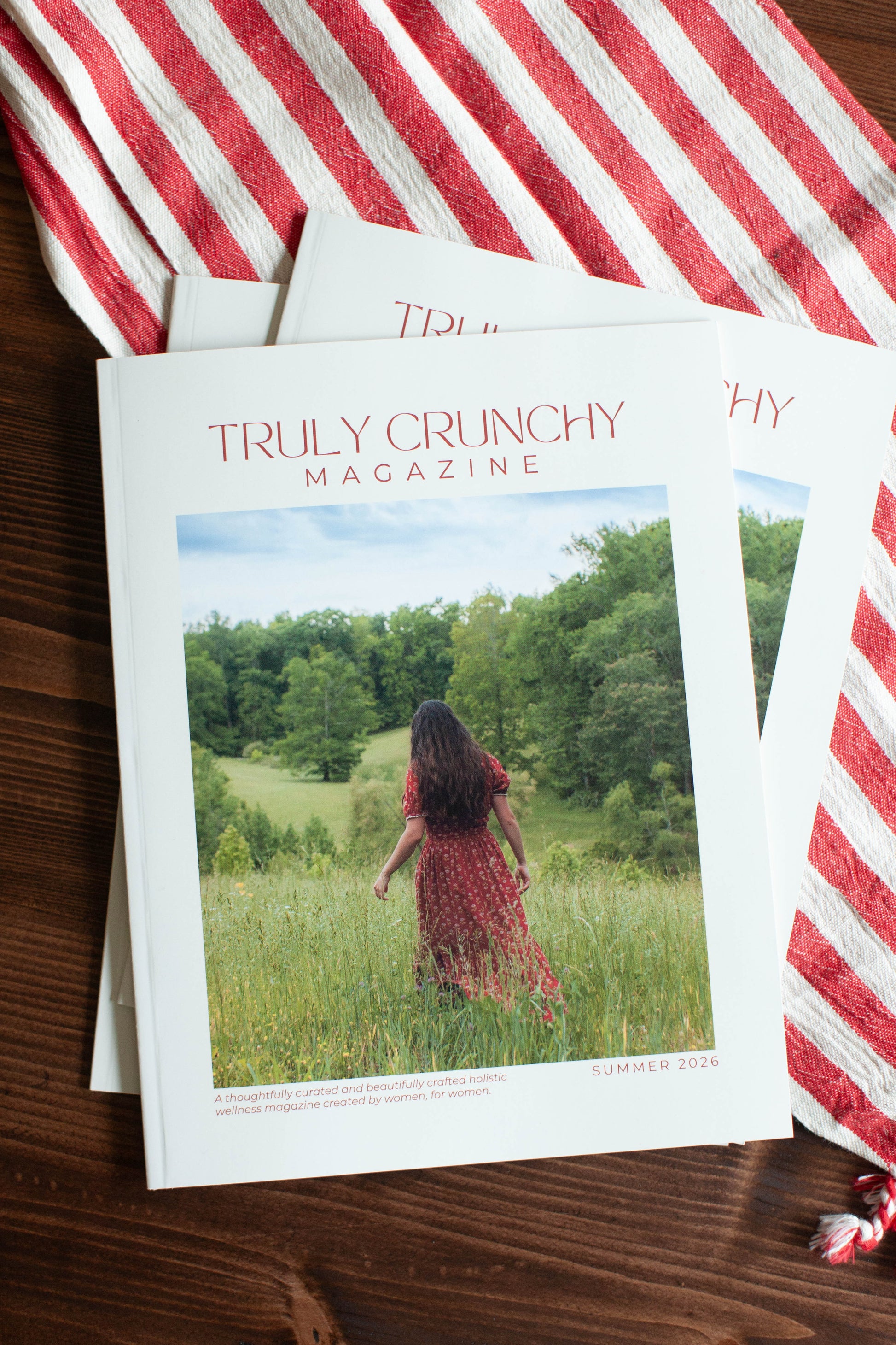 Truly Crunchy magazine on a wooden surface with a red and white striped towel.