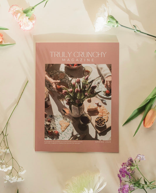 Magazine titled 'Truly Crunchy' on a light surface with flowers around